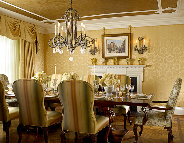 Esempio di una sala da pranzo tradizionale chiusa e di medie dimensioni con pareti gialle, pavimento marrone e camino classico