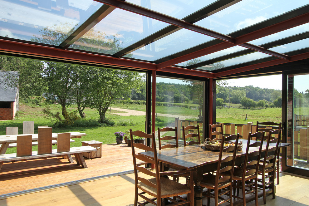 Farmhouse open plan dining room in Surrey with light hardwood flooring.