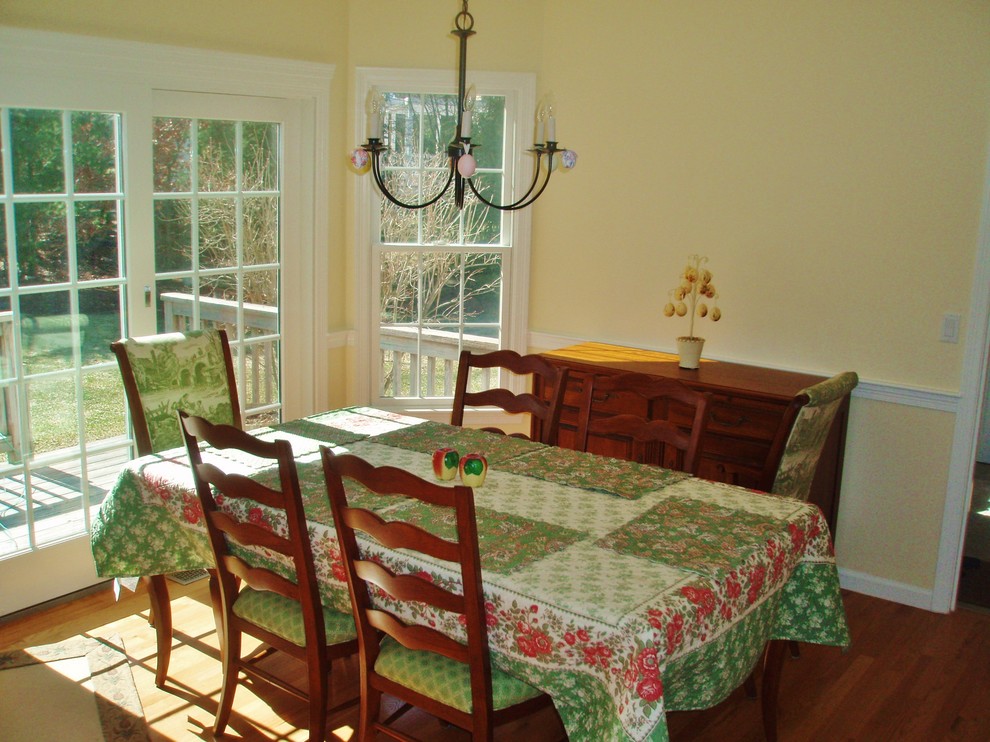 Foto di una sala da pranzo aperta verso la cucina tradizionale di medie dimensioni con pareti gialle, parquet chiaro e nessun camino