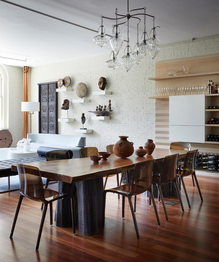 Idee per una sala da pranzo aperta verso il soggiorno minimal di medie dimensioni con pareti bianche, pavimento in legno massello medio e pavimento marrone