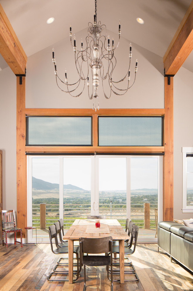 Imagen de comedor campestre grande abierto con paredes grises y suelo de madera en tonos medios