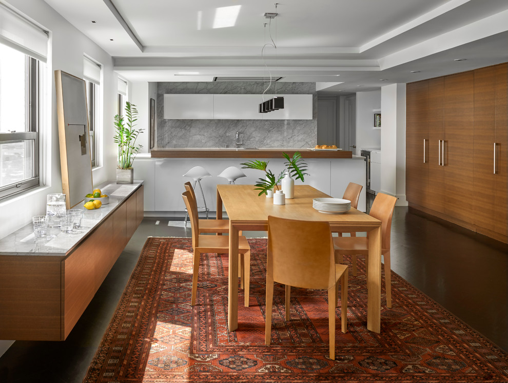 Idée de décoration pour une salle à manger ouverte sur la cuisine design de taille moyenne avec parquet foncé et un mur blanc.