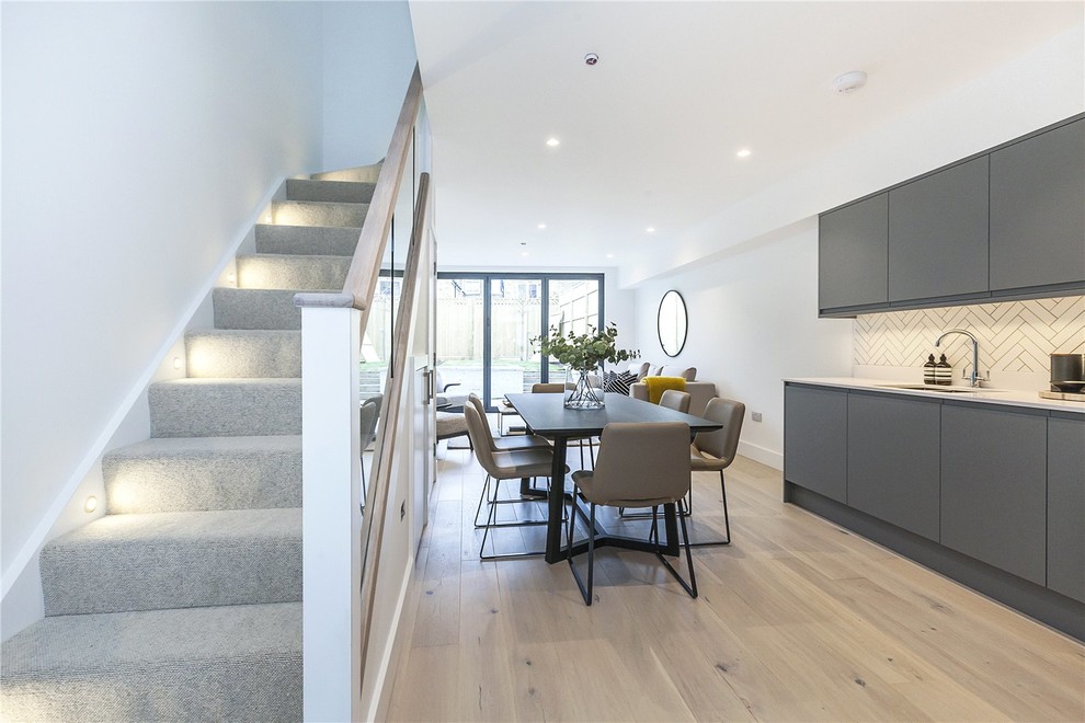 Mittelgroße Moderne Wohnküche mit weißer Wandfarbe, braunem Holzboden und beigem Boden in London