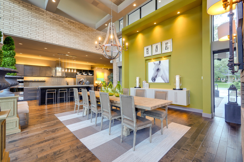 Exemple d'une grande salle à manger ouverte sur le salon tendance avec un mur vert et un sol en bois brun.