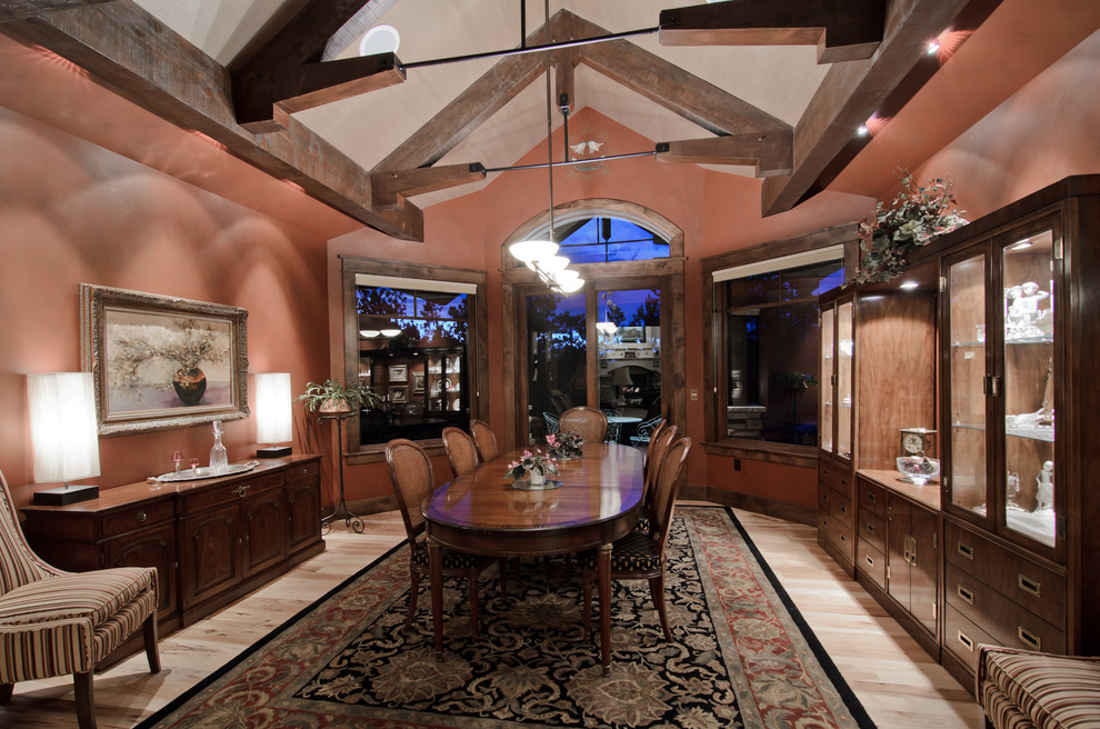 Aménagement d'une salle à manger classique avec un sol en bois brun et un mur rose.