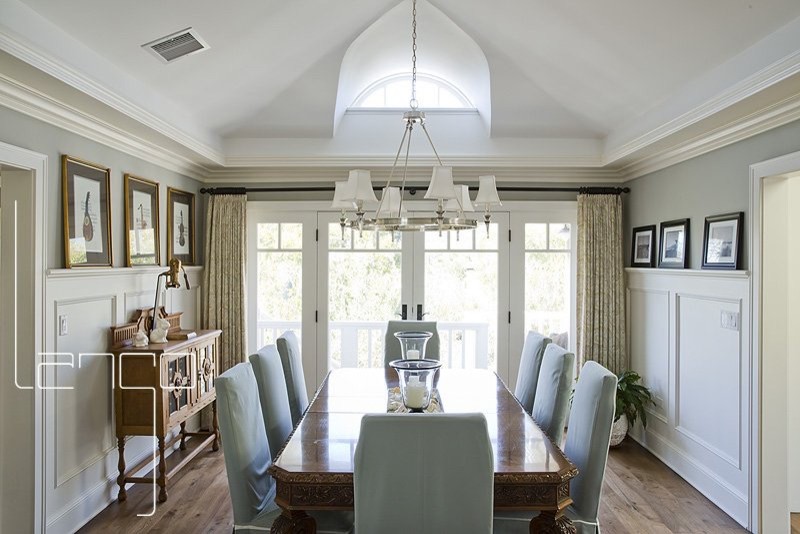 This is an example of a large coastal enclosed dining room in Los Angeles with painted wood flooring, brown floors and grey walls.