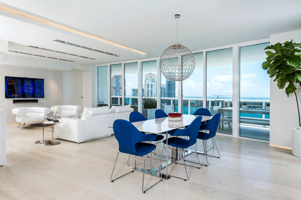 Immagine di una sala da pranzo aperta verso la cucina design con pareti bianche e parquet chiaro