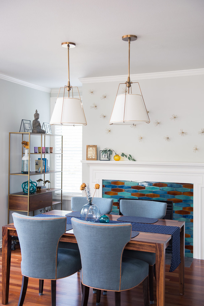 Réalisation d'une petite salle à manger ouverte sur le salon tradition avec un mur bleu, un sol en bois brun, une cheminée standard, un manteau de cheminée en carrelage et un sol marron.