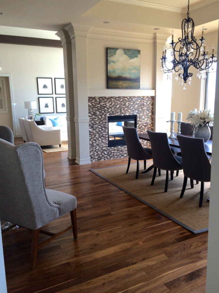 Mittelgroße Moderne Wohnküche mit beiger Wandfarbe, braunem Holzboden, Tunnelkamin, gefliester Kaminumrandung und braunem Boden in Calgary