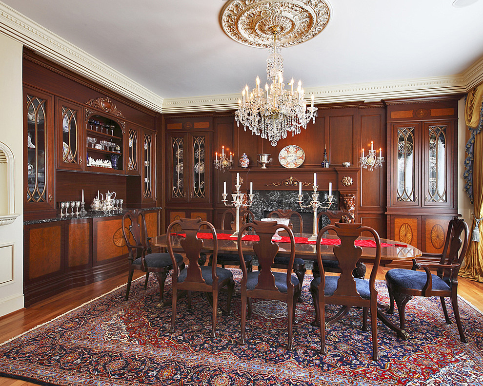 Photo of a large traditional enclosed dining room in DC Metro with dark hardwood flooring, beige walls, a standard fireplace, a stone fireplace surround and brown floors.