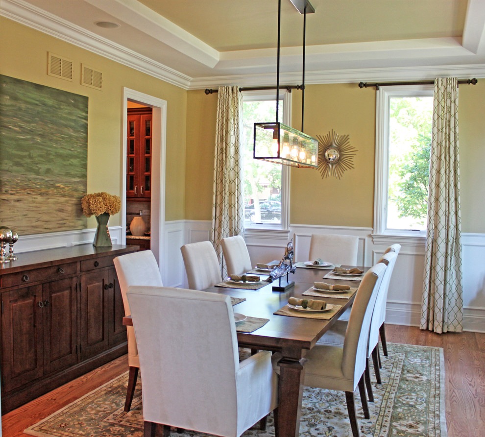 Enclosed dining room - large transitional dark wood floor enclosed dining room idea in Chicago with yellow walls