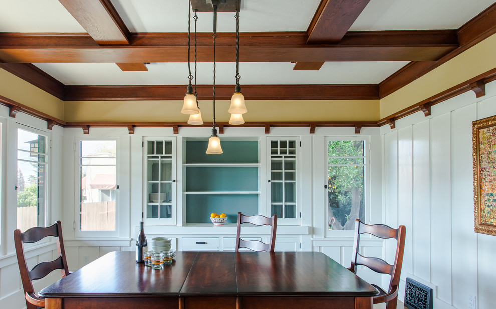 Example of a mid-sized arts and crafts medium tone wood floor enclosed dining room design in Santa Barbara with yellow walls and no fireplace