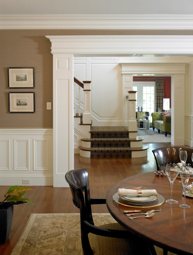 Example of a large classic dark wood floor and brown floor enclosed dining room design in Boston with brown walls