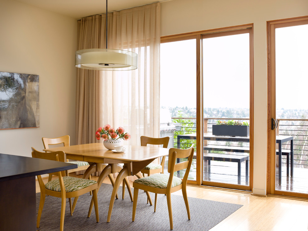 Ispirazione per una sala da pranzo aperta verso il soggiorno moderna con parquet chiaro e pareti beige