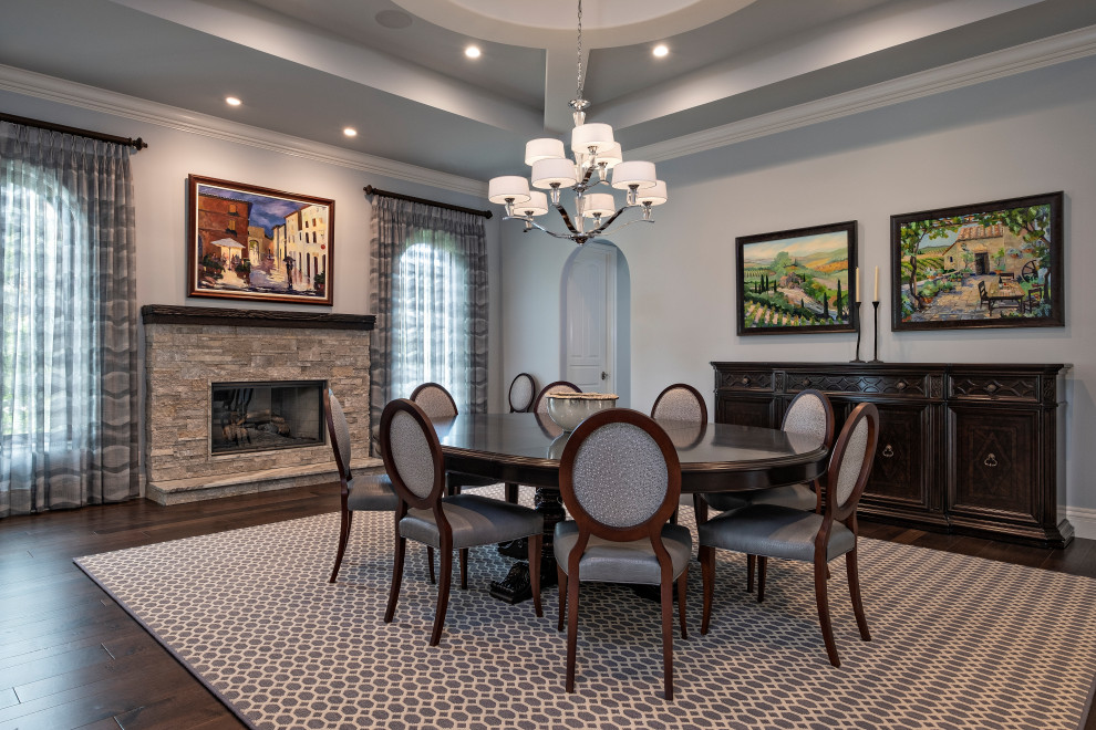 Design ideas for a traditional dining room in Miami with grey walls, dark hardwood flooring, a standard fireplace, a stacked stone fireplace surround, brown floors and a drop ceiling.