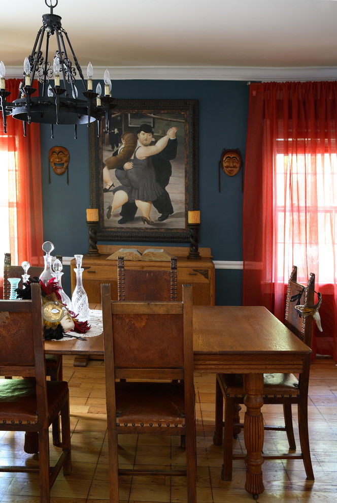Imagen de comedor ecléctico grande cerrado con paredes azules, suelo de madera en tonos medios y todas las chimeneas