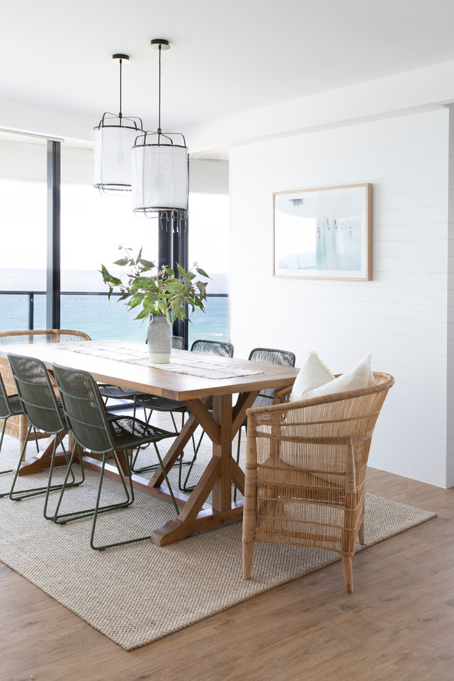 Esempio di una sala da pranzo aperta verso la cucina stile marinaro di medie dimensioni con pareti bianche, pavimento in vinile e pavimento marrone