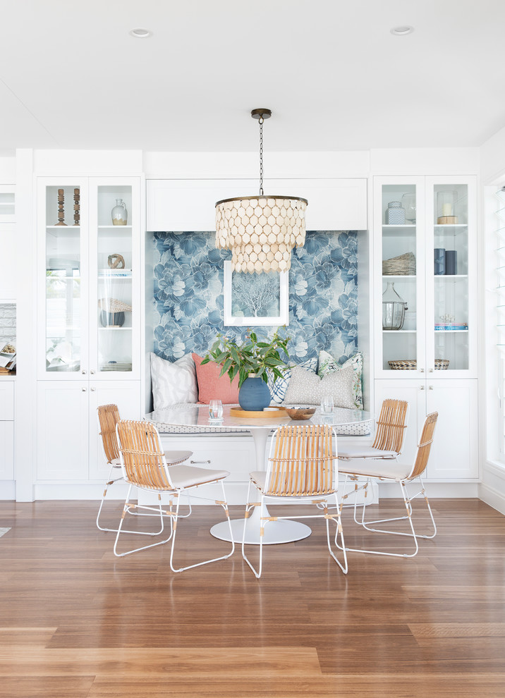 Inspiration pour une salle à manger ouverte sur la cuisine marine de taille moyenne avec un mur blanc, un sol marron et un sol en vinyl.