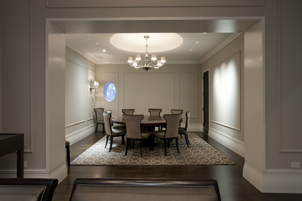 Réalisation d'une grande salle à manger tradition avec un mur blanc et parquet foncé.