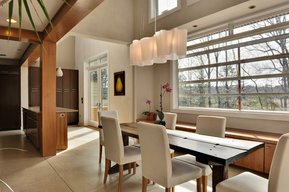 Foto di una sala da pranzo aperta verso la cucina minimal con pareti bianche