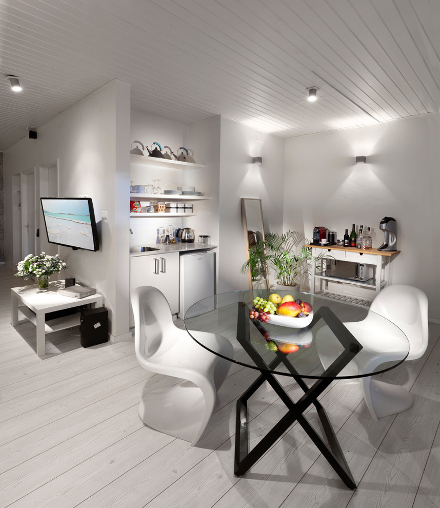 Réalisation d'une salle à manger design avec un mur blanc, parquet peint et un sol blanc.