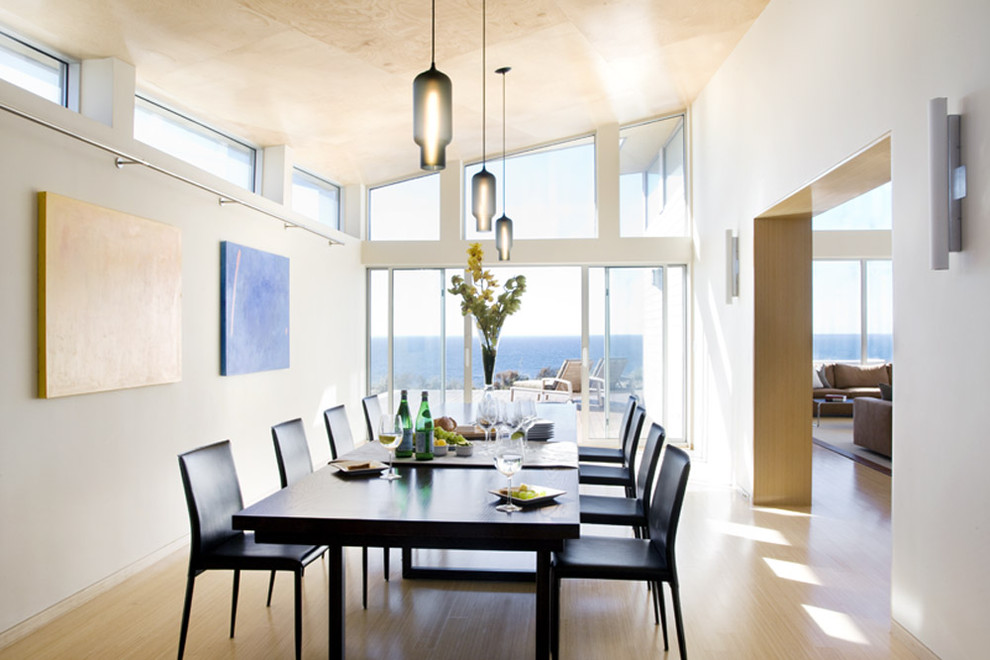Photo of a contemporary dining room in Boston with white walls, light hardwood flooring and feature lighting.