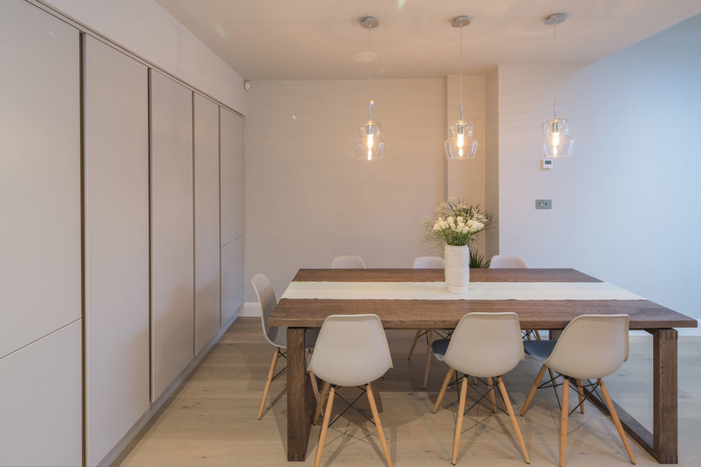 Diseño de comedor de cocina actual de tamaño medio con paredes blancas y suelo de madera clara