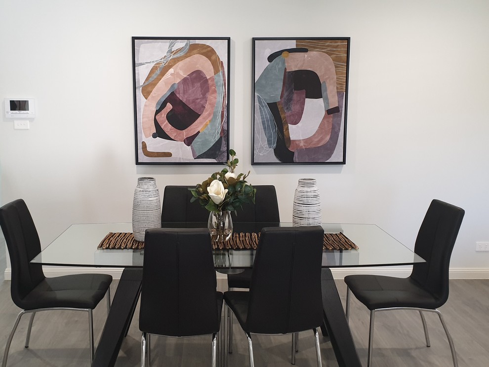 Ispirazione per una sala da pranzo minimal con pareti bianche, pavimento in laminato e pavimento grigio