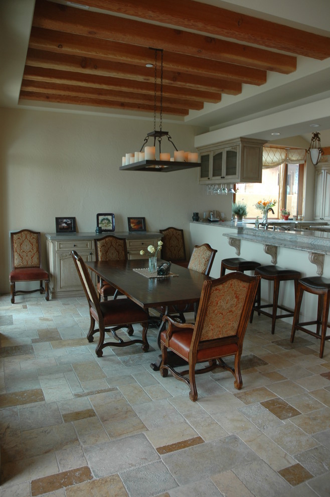 This is an example of a medium sized mediterranean kitchen/dining room in New York with a standard fireplace, a stone fireplace surround, beige walls and limestone flooring.