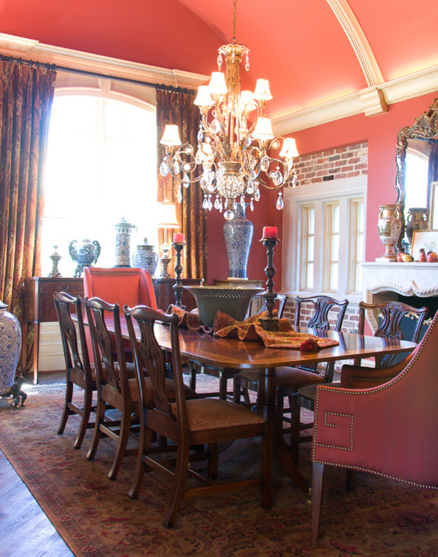 Exemple d'une salle à manger chic fermée et de taille moyenne avec un mur rouge et une cheminée standard.