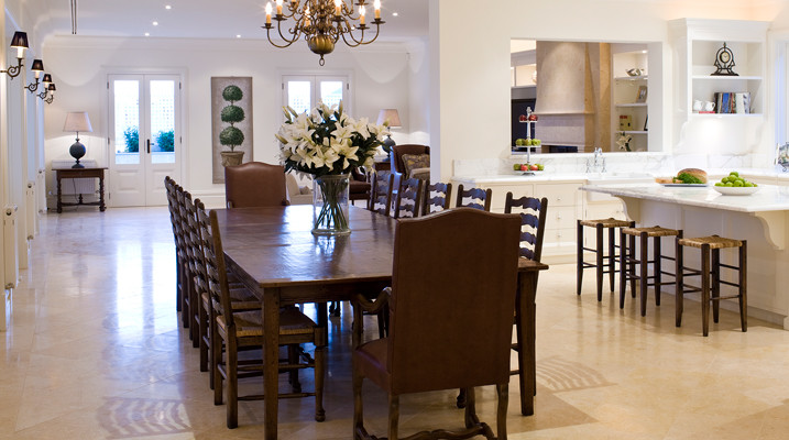 Exemple d'une grande salle à manger ouverte sur le salon chic avec un mur blanc et un sol beige.