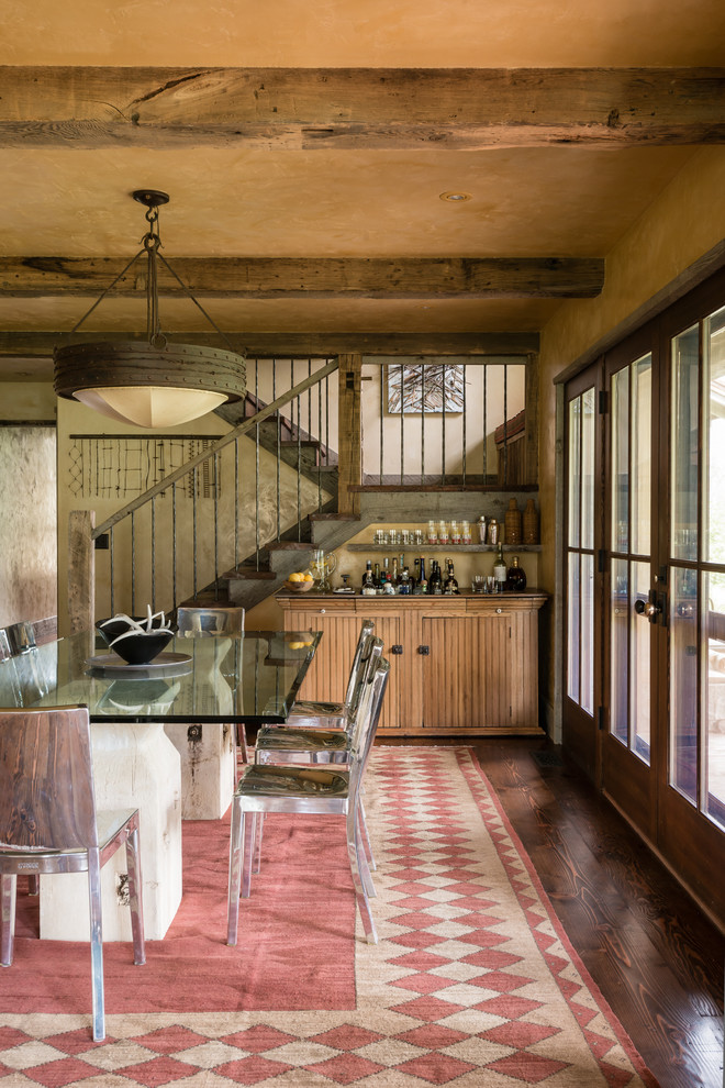 Rustic dining room in Other with beige walls and dark hardwood flooring.