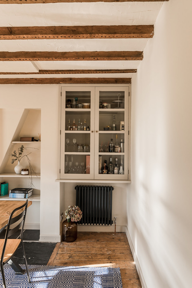 Cette photo montre une salle à manger scandinave fermée et de taille moyenne avec un mur blanc, un sol en bois brun et un sol marron.