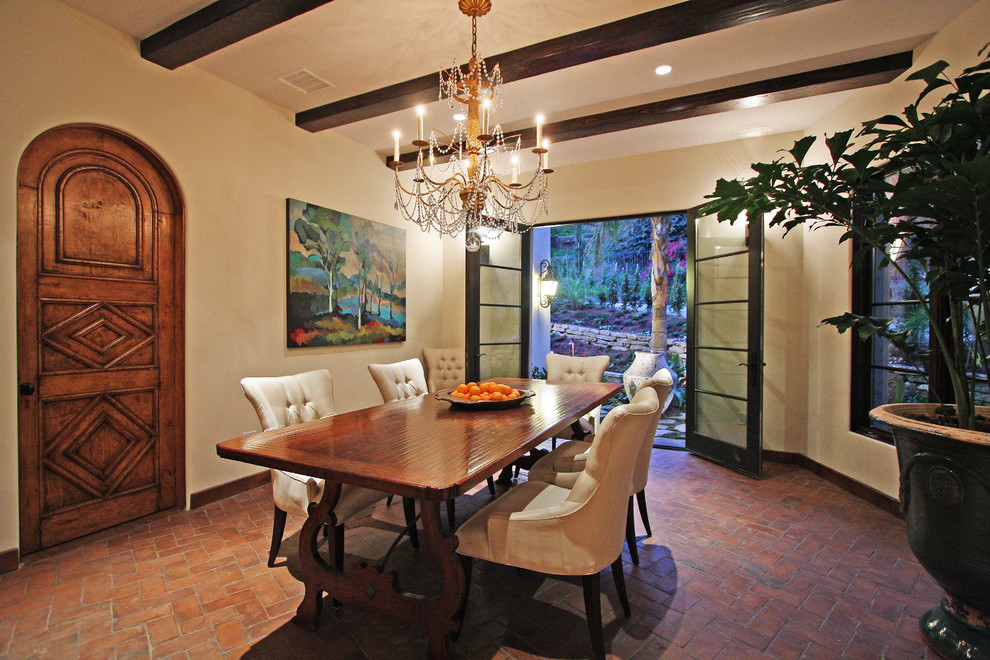 Immagine di una sala da pranzo aperta verso il soggiorno mediterranea di medie dimensioni con pareti beige e pavimento in mattoni