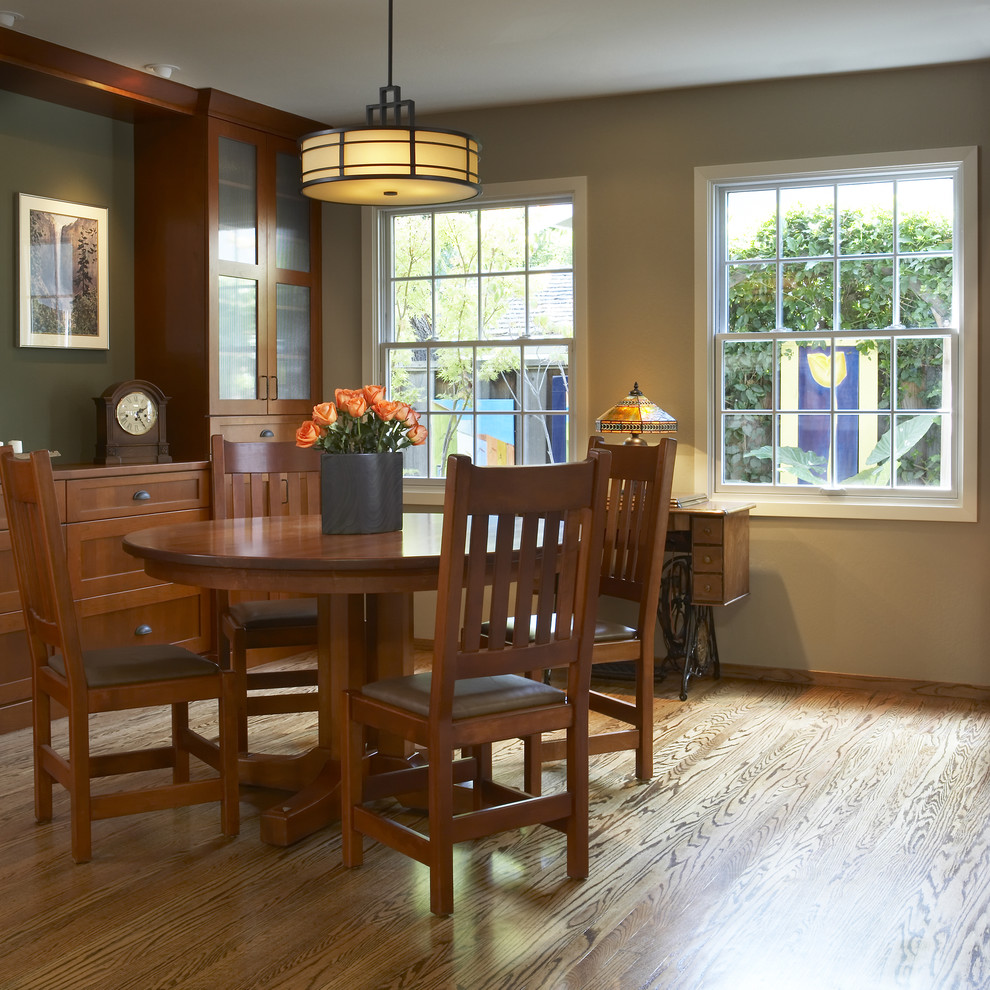 Aménagement d'une salle à manger craftsman avec un mur beige et un sol en bois brun.