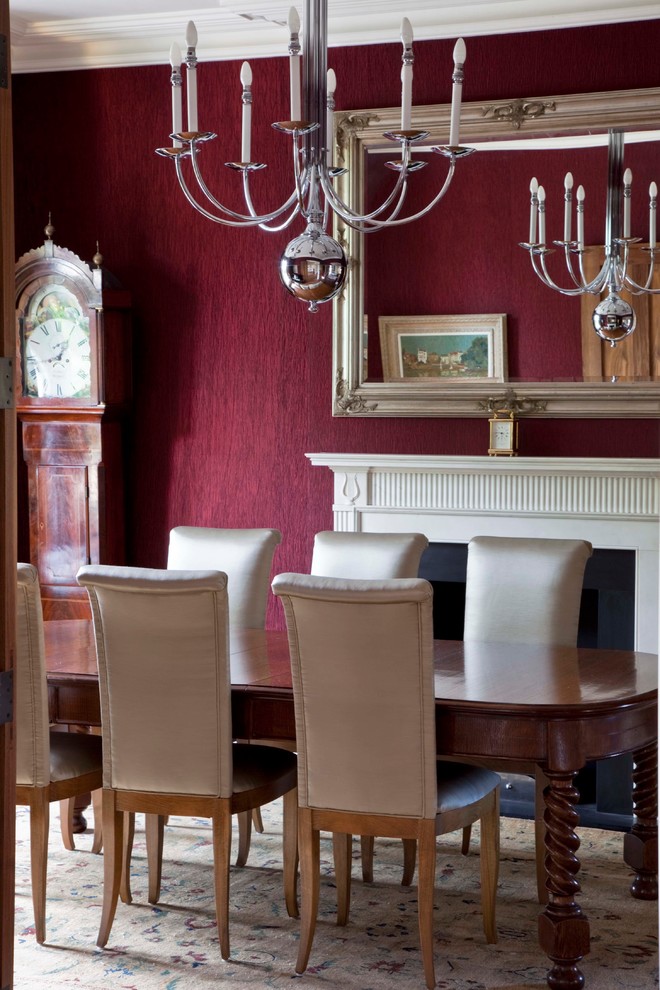 Ispirazione per una grande sala da pranzo chic chiusa con pareti rosse, camino classico e moquette