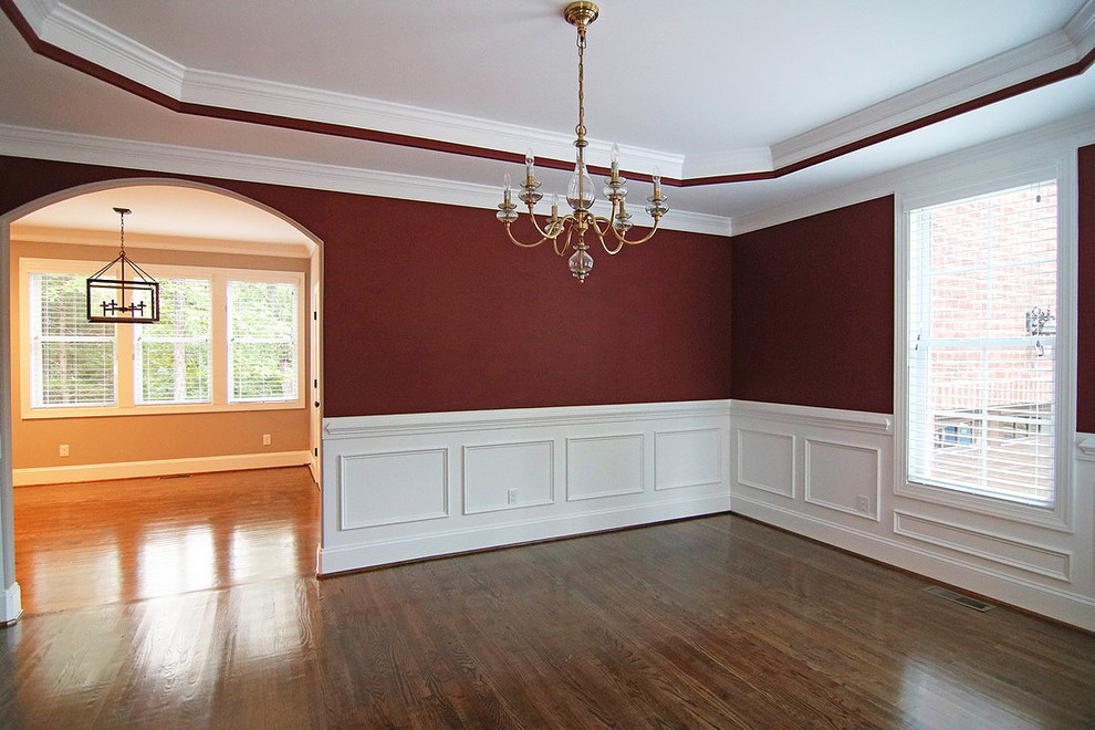 Exemple d'une grande salle à manger chic fermée avec un mur rouge, un sol en bois brun et un sol marron.