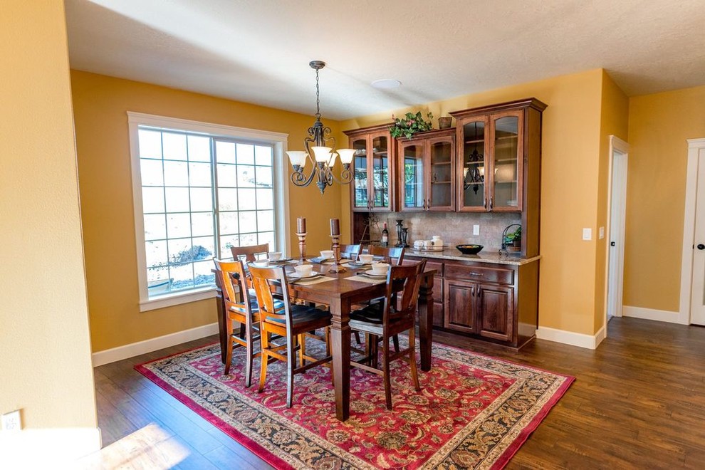 Photo of a classic open plan dining room in Portland with yellow walls and brown floors.