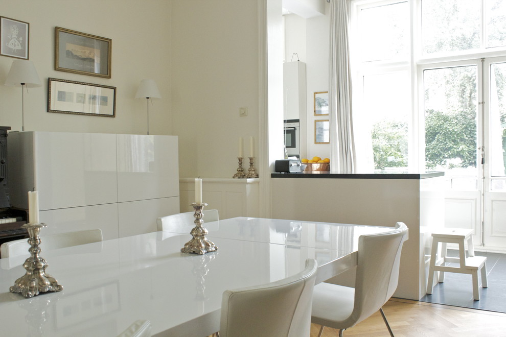 Idee per una sala da pranzo aperta verso la cucina contemporanea con pareti bianche, pavimento in legno massello medio e pavimento beige
