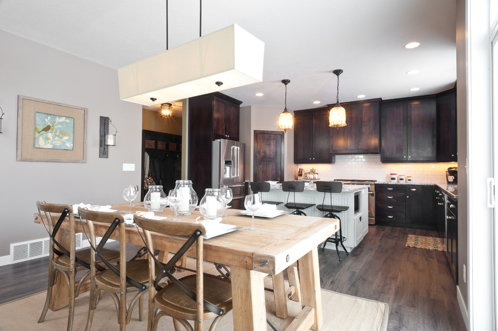 Idée de décoration pour une salle à manger ouverte sur la cuisine design avec un mur gris et parquet foncé.