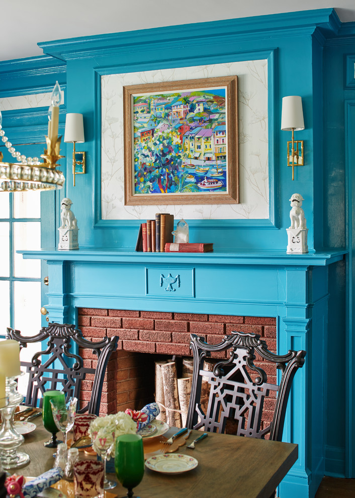 На фото: столовая среднего размера в стиле неоклассика (современная классика) с синими стенами, стандартным камином и фасадом камина из кирпича с