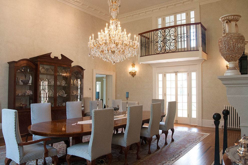 Foto di una grande sala da pranzo aperta verso la cucina tradizionale con pareti bianche, pavimento in legno massello medio, camino classico e pavimento marrone