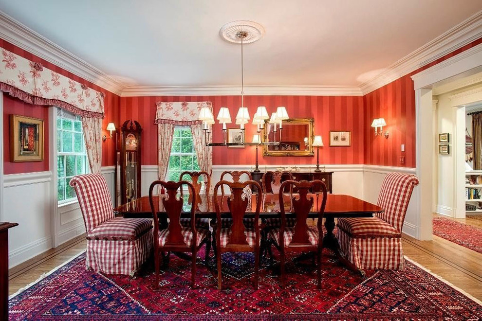 Foto de comedor clásico grande cerrado sin chimenea con paredes rojas, suelo de madera en tonos medios y suelo marrón