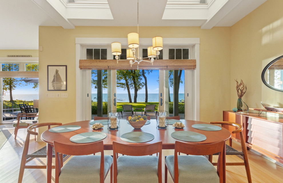 Idée de décoration pour une salle à manger ouverte sur le salon marine de taille moyenne avec un mur jaune, parquet clair et un sol jaune.