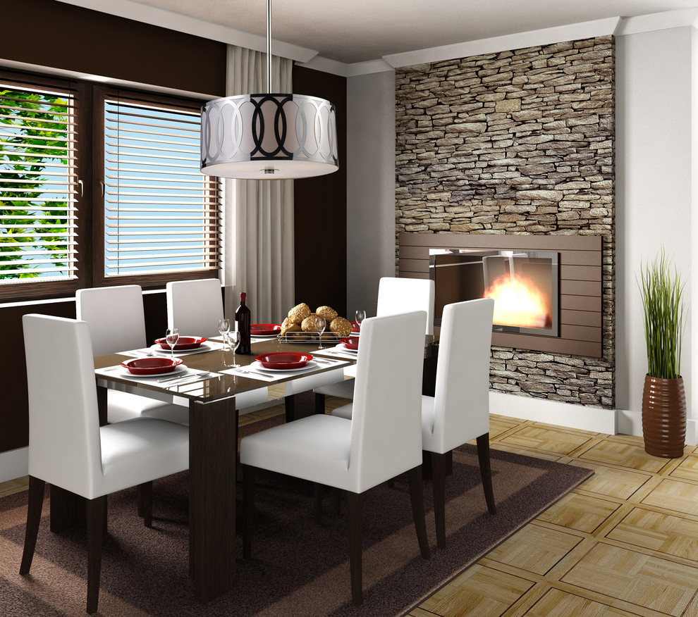 Exemple d'une salle à manger tendance fermée et de taille moyenne avec un mur noir, un sol en bois brun, une cheminée standard et un manteau de cheminée en brique.