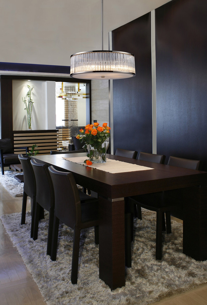 Mid-sized trendy medium tone wood floor enclosed dining room photo in New York with black walls