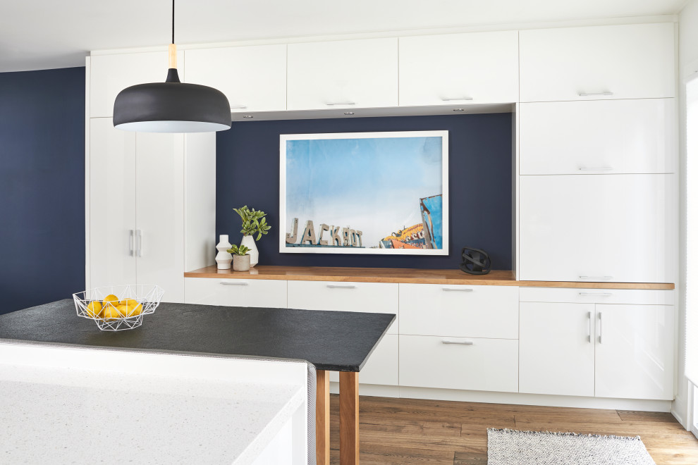 Modelo de comedor de cocina minimalista de tamaño medio con paredes azules y suelo de madera en tonos medios