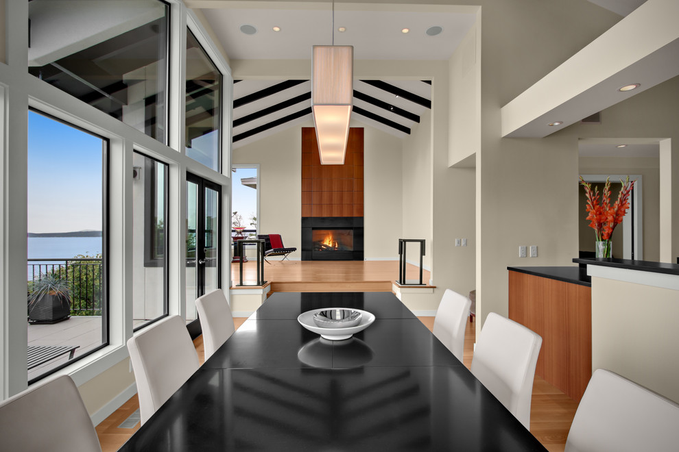 Exemple d'une salle à manger ouverte sur la cuisine chic avec un mur beige et un sol en bois brun.