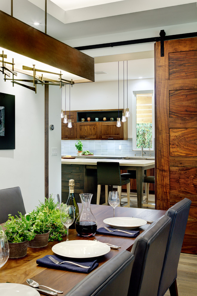 Mittelgroße Moderne Wohnküche ohne Kamin mit weißer Wandfarbe und gebeiztem Holzboden in Sacramento