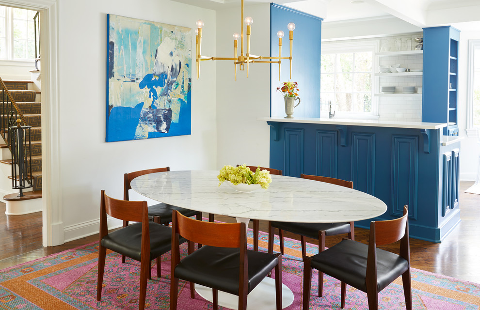 Ispirazione per una grande sala da pranzo aperta verso la cucina stile marino con pareti bianche, pavimento in legno massello medio e pavimento marrone
